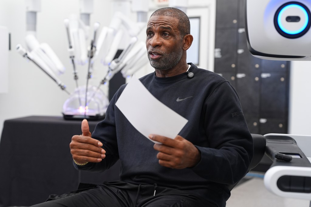 Deion Sanders speaks while demonstrating the Da Vinci robotic surgical machine.