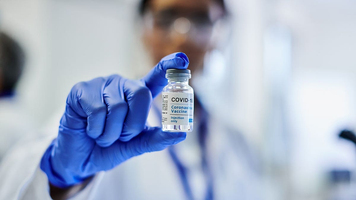 A doctor holding up a vial of a Covid-19 vaccine.