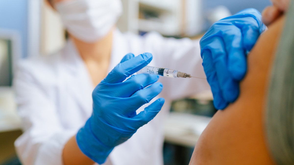 Senior adult man receiving vaccination in a doctor's office.