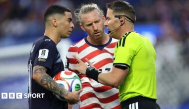 Referee Danny Makkelie speaks to the Miguel Almiron of Paraguay and USA defender Tim Ream during a VAR check for 'mistaken identify'