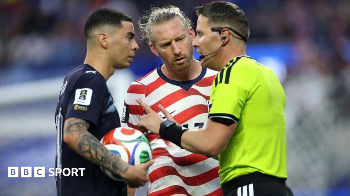 Referee Danny Makkelie speaks to the Miguel Almiron of Paraguay and USA defender Tim Ream during a VAR check for 'mistaken identify'