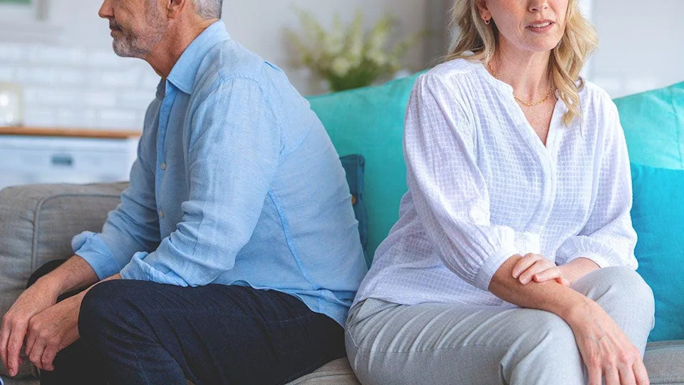 man and woman face backs toward each other