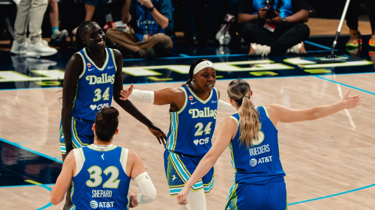 Dallas Wings players Awak Kuier, Jessica Shepard, Arike Ogunbowale, and Paige Bueckers celebrate during a WNBA game against the Las Vegas Aces at College Park Center in Arlington, Texas, on June 15, 2026.