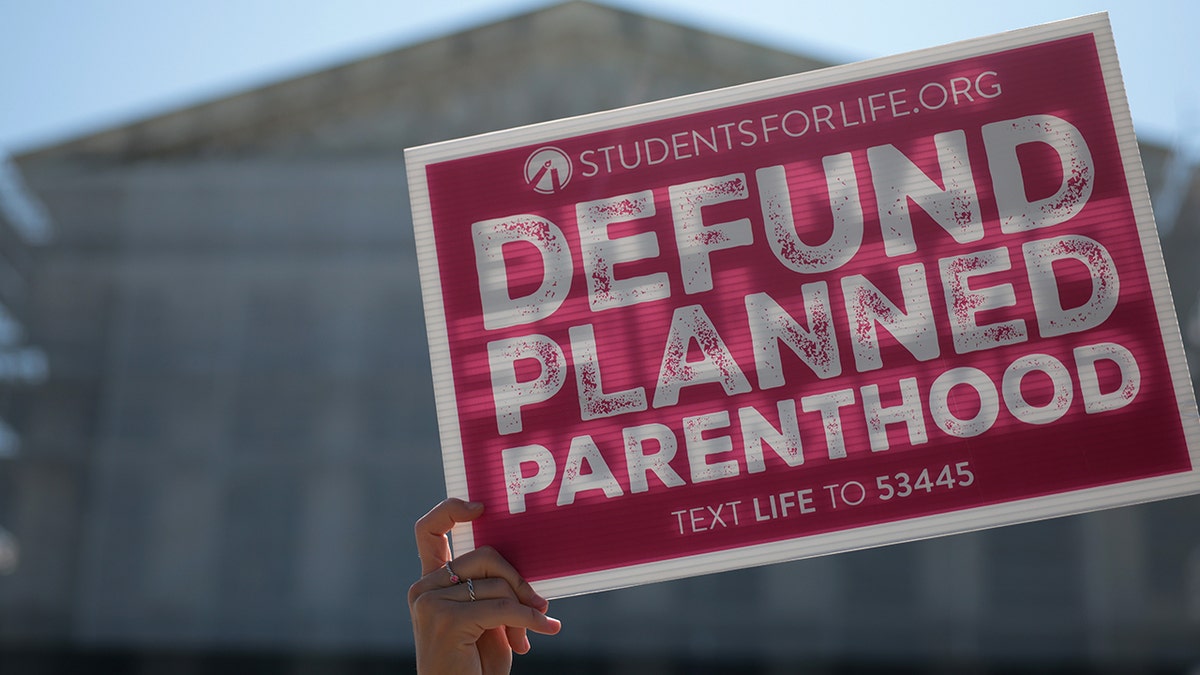 Protestors holding Defund Planned Parenthood signs outside the U.S. Supreme Court in Washington, D.C.