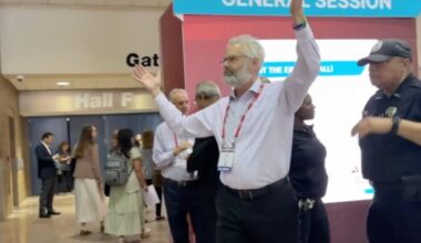 Police escort Dr. Steven Kahn out of a medical conference in New Orleans for handling out copies