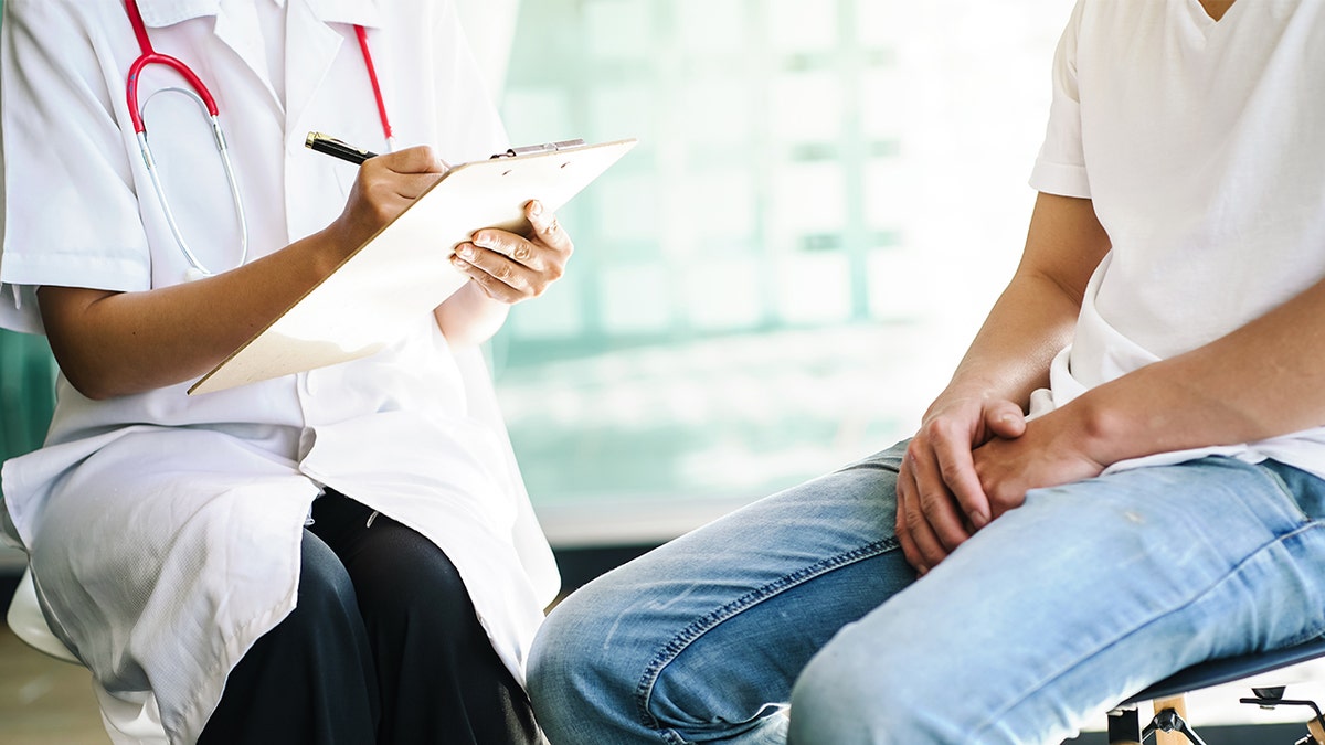 Female doctor asking questions to prostate cancer patient during consultation.