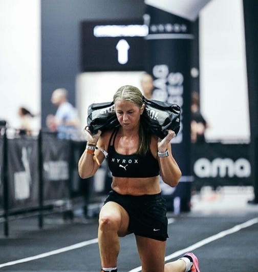 Athlete lunging with sandbag during a fitness event. Athlete lunging with sandbag during a fitness event.