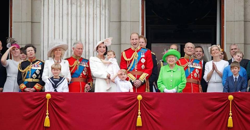 Queen Elizabeth II in neon green surrounded by her family on the balcony