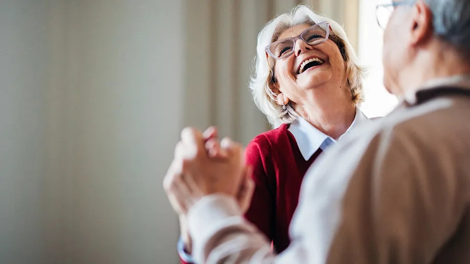 Elderly couple dancing together joyfully indoors