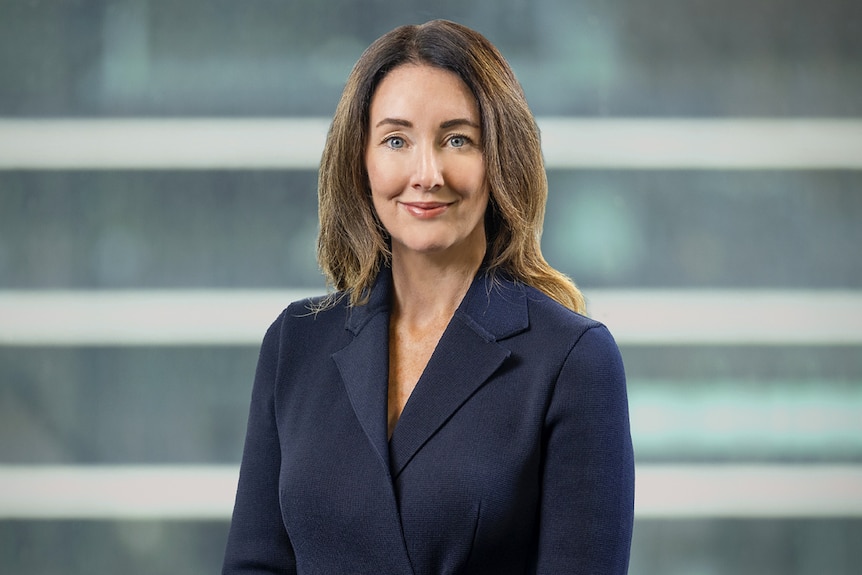 A woman stands looking at the camera