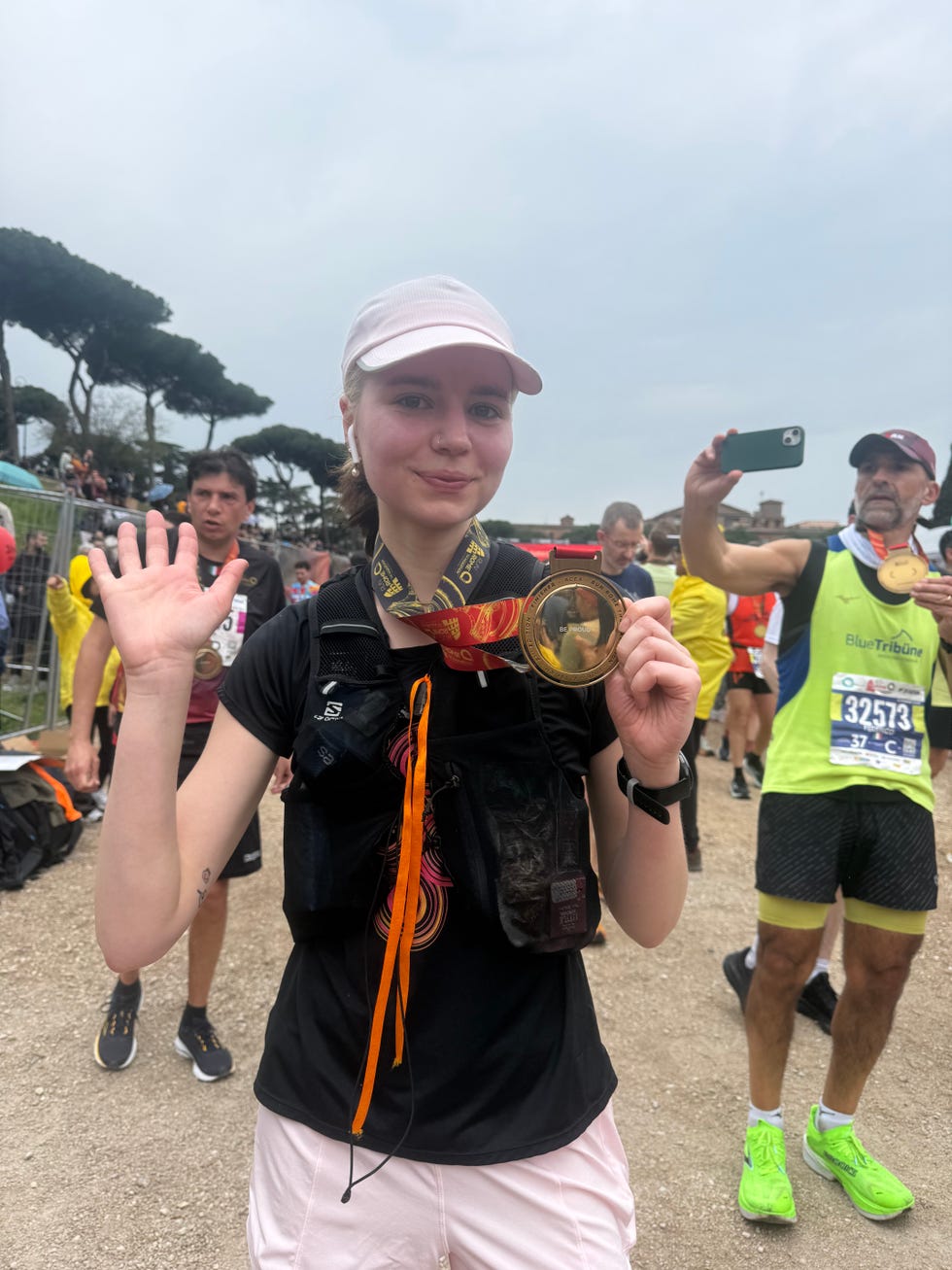 runner at the finish line of a marathon with medal in hand