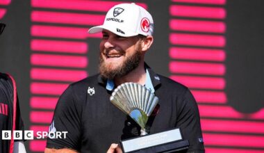 Tyrrell Hatton smiles as he holds the trophy for winning in Andalucia