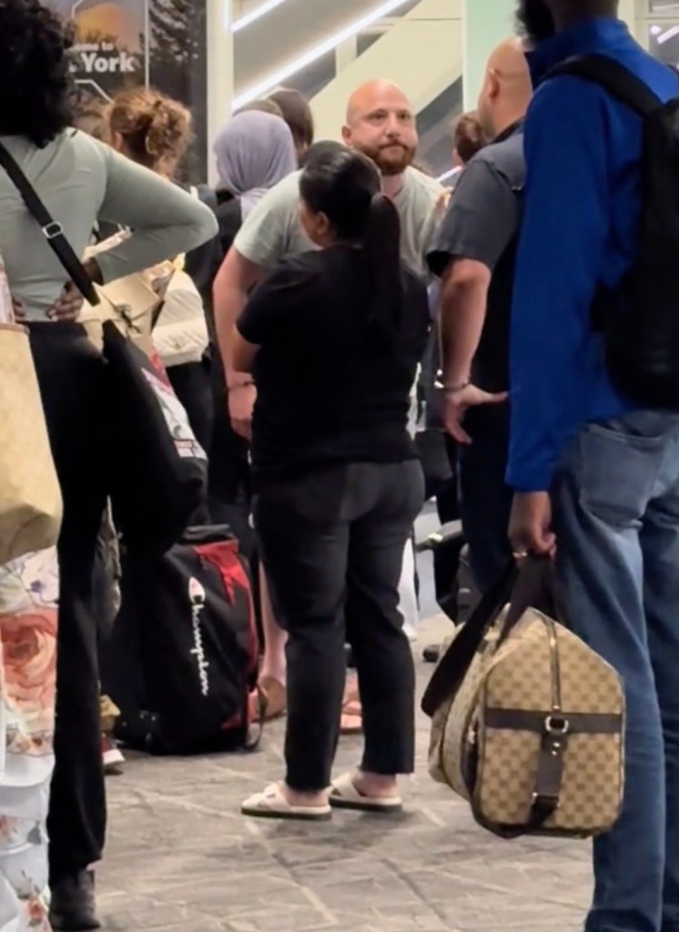 A man stands between two girls and another passenger.