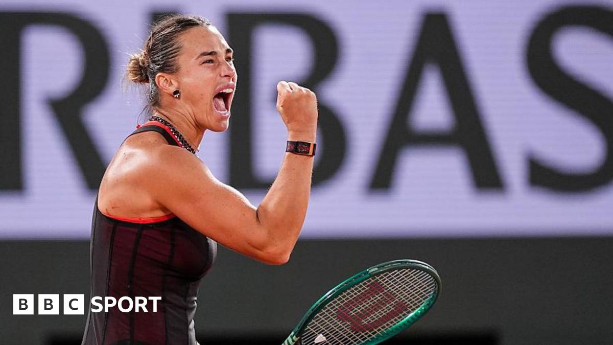 Aryna Sabalenka, wearing a black dress and holding her green racquet in her left hand, screams and clenches her right fist in celebration