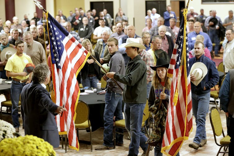 Wearing cowboy hats and carrying American flags, farmers and ranchers call on the Trump administration to conclude trade talks on favorable terms.
