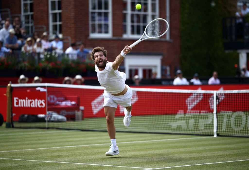 Tennis player Corentin Moutet serves the ball during a match.