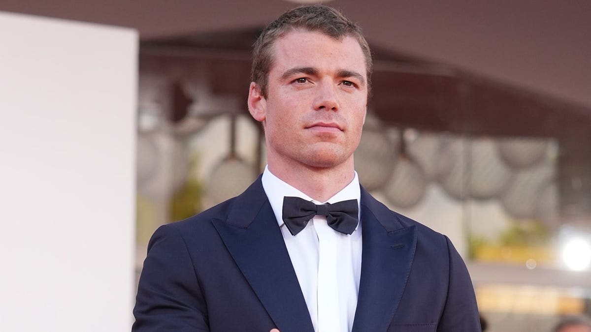 Gabriel Basso standing on the red carpet at the Venice International Film Festival.