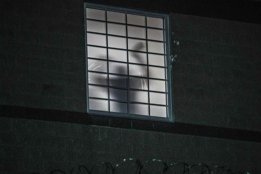 The silhouette of a person believed to be a detainee is seen through a window of Delaney Hall detention center in Newark, New Jersey, on Friday.