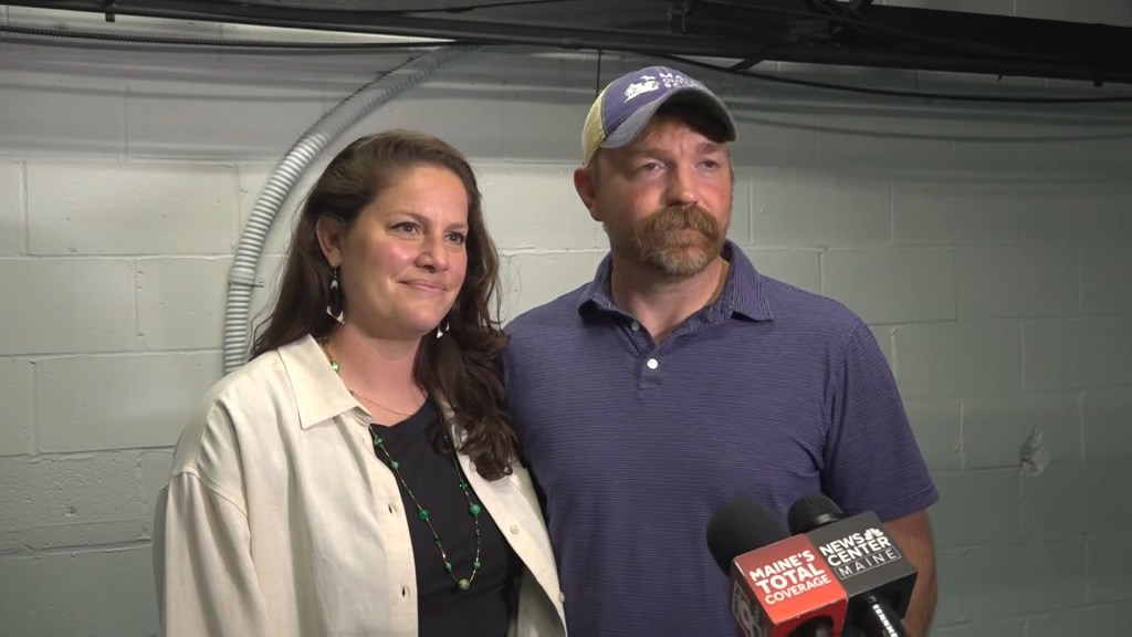 Graham Platner and his wife Amy Gertner standing together during an interview.