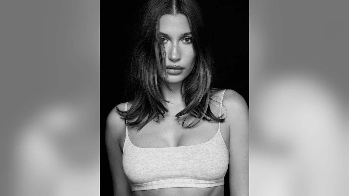 Hailey Bieber modeling SKIMS clothing in a studio setting