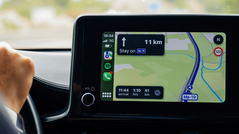 A close-up of a car's infotainment screen displaying CarPlay navigation