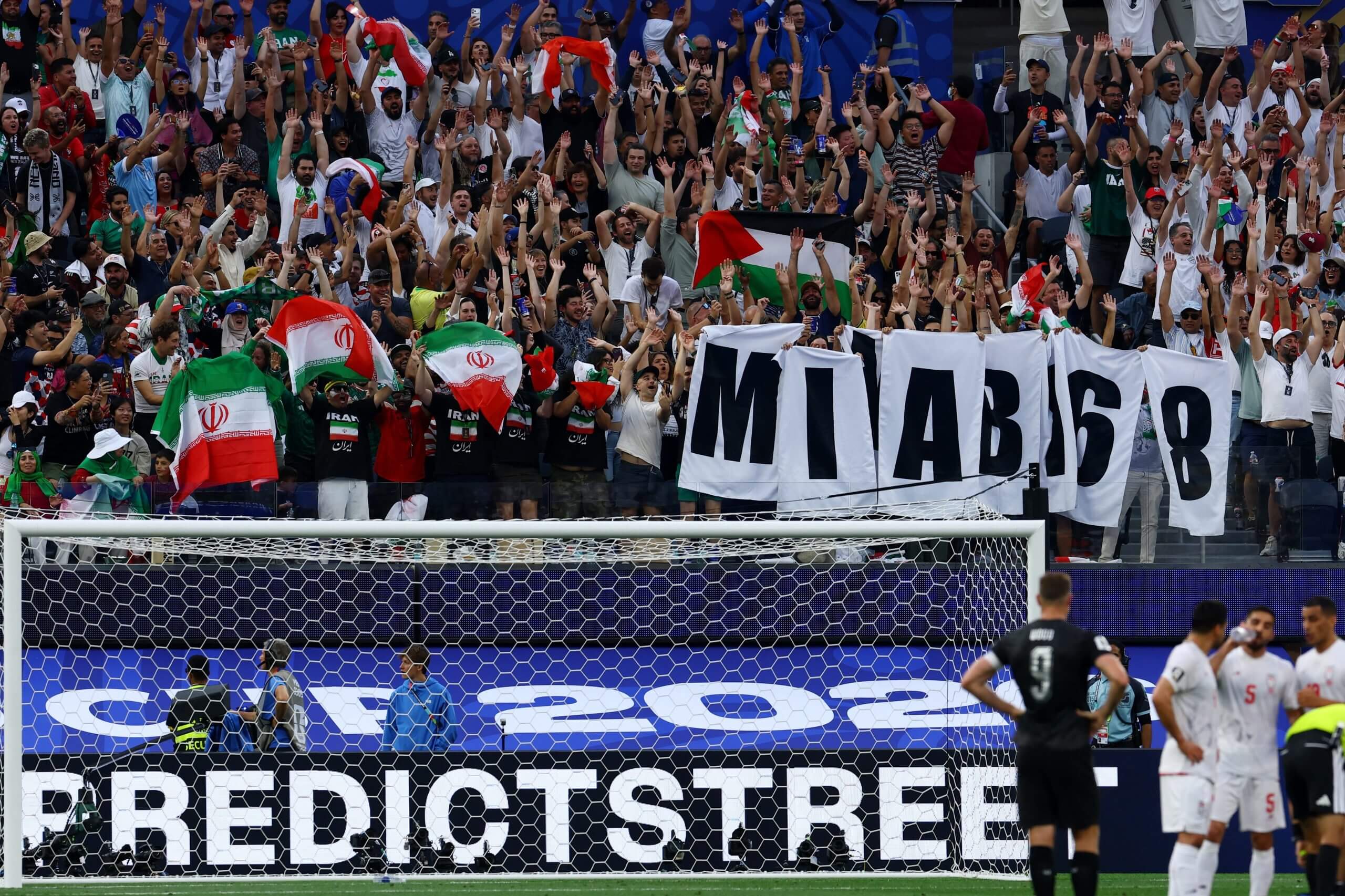 Iranian fans waving flags and a sign that reads MINAB 168