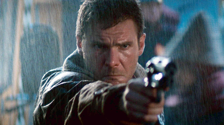 Harrison Ford as Deckard holding his gun in the rain in Blade Runner