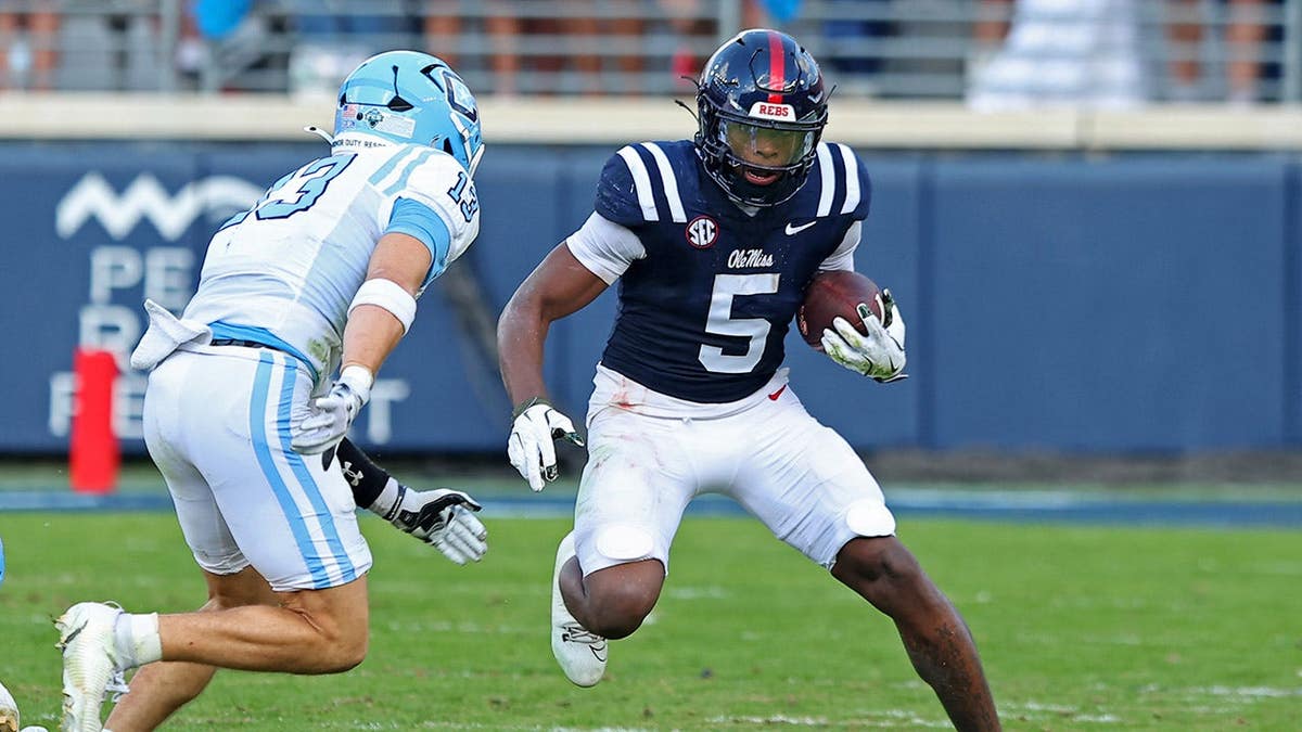 Kewan Lacy running with football past Cale Williams at Vaught-Hemingway Stadium