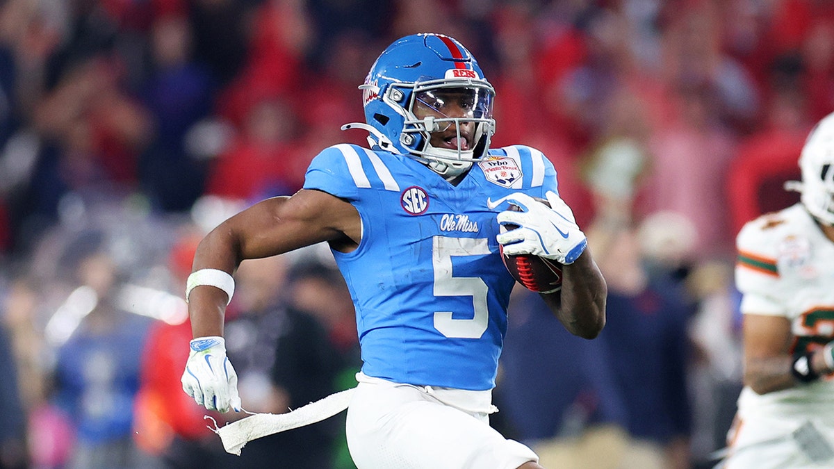 Kewan Lacy of Ole Miss carrying the ball running for a touchdown in a football game