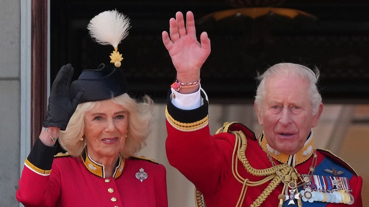 King Charles III and Queen Camilla waving from Buckingham Palace balcony