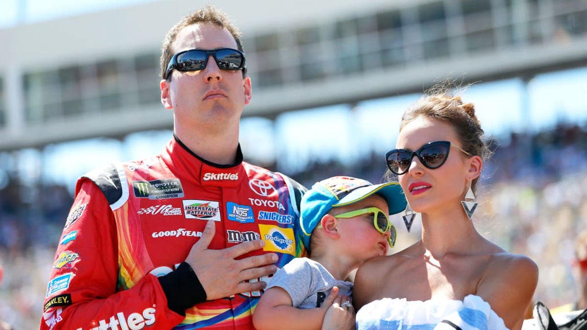Kyle Busch standing on the grid with his wife Samantha and son Brexton at Phoenix International Raceway
