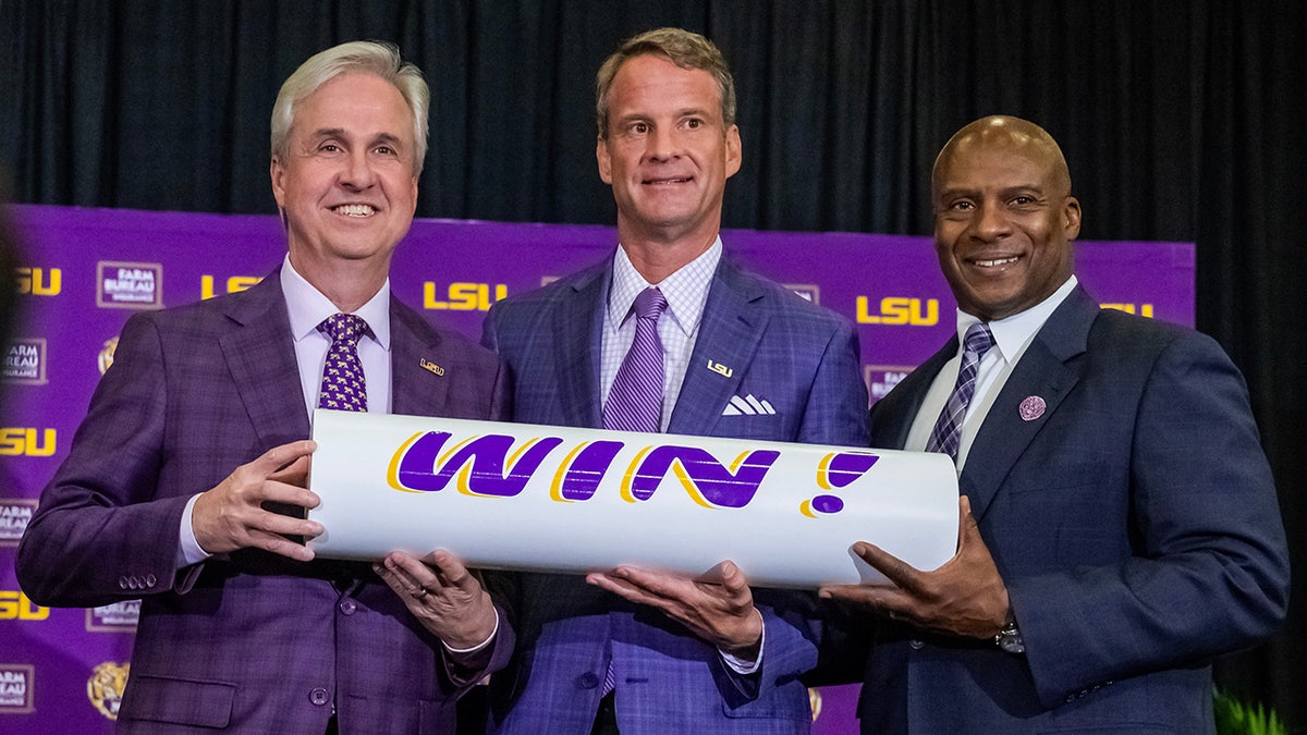 LSU president Wade Rousse and athletic director Verge Ausberry pose with head football coach Lane Kiffin at a news conference