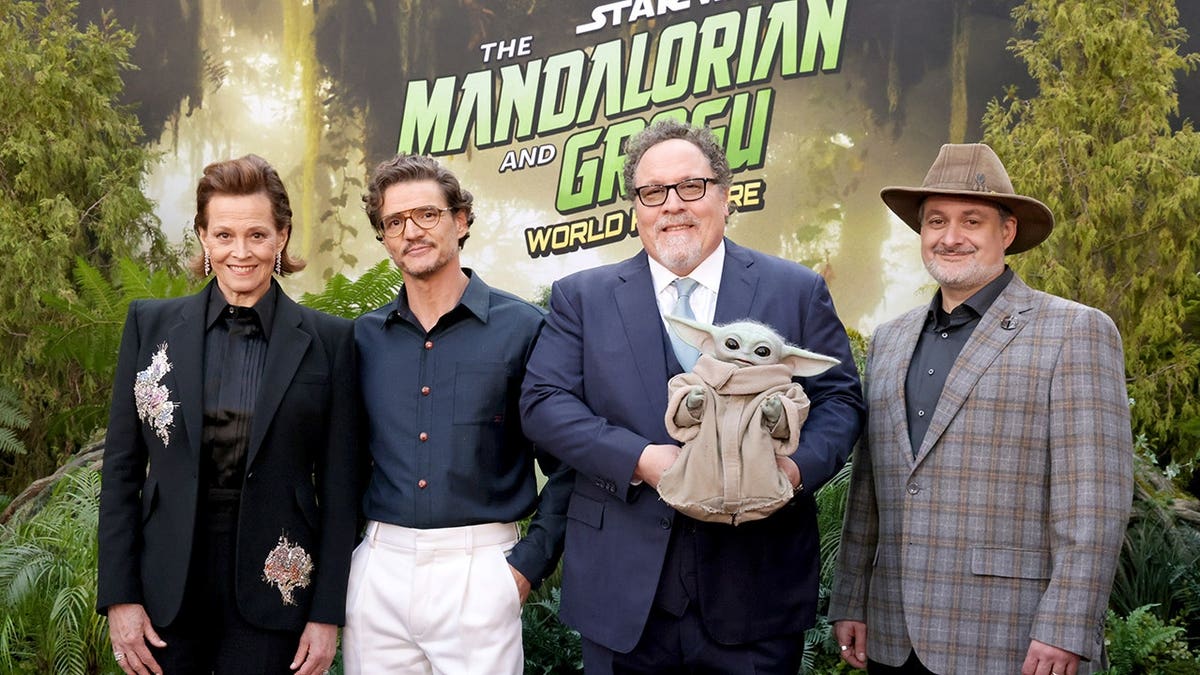Sigourney Weaver, Pedro Pascal, Jon Favreau, and Dave Filoni standing together at The Mandalorian and Grogu Los Angeles premiere