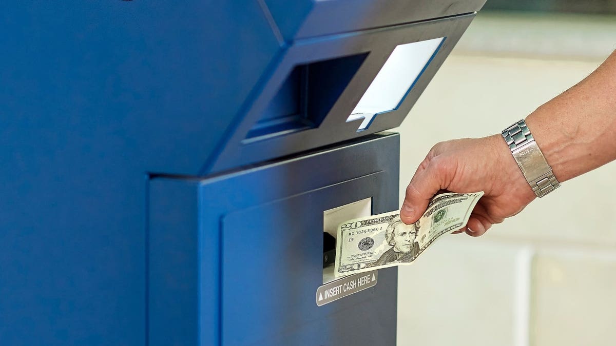 A man putting money into an ATM