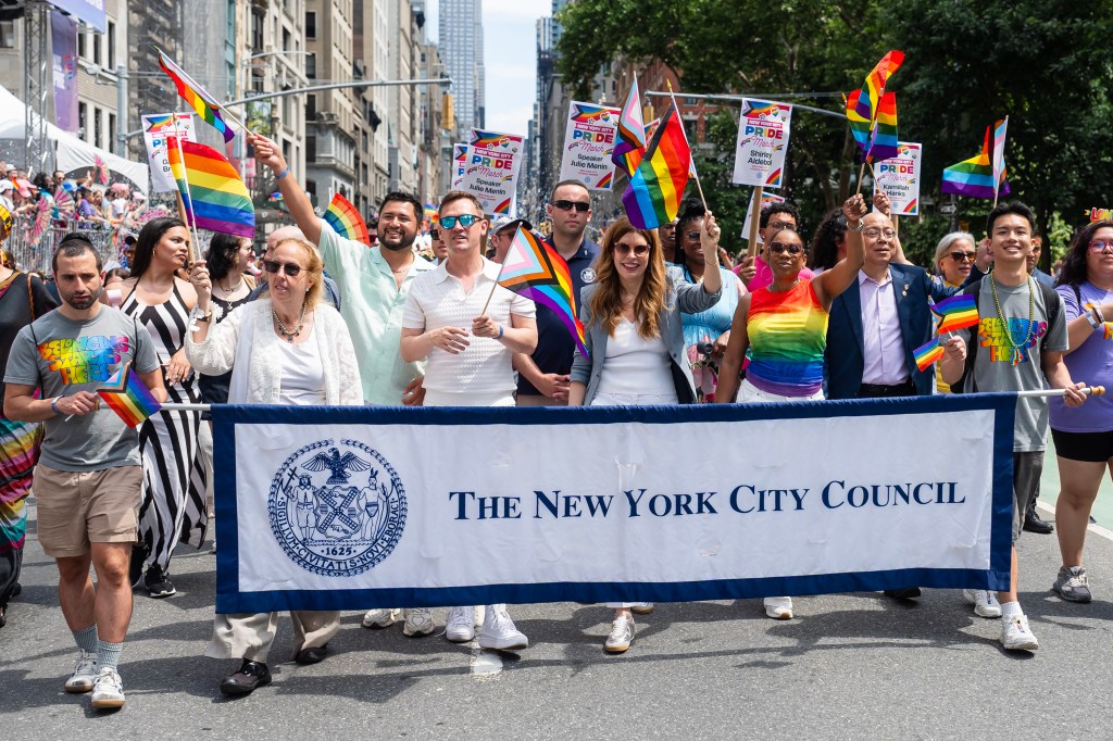 New York City Council members carry a banner and rainbow flags at the 2026 Pride March.