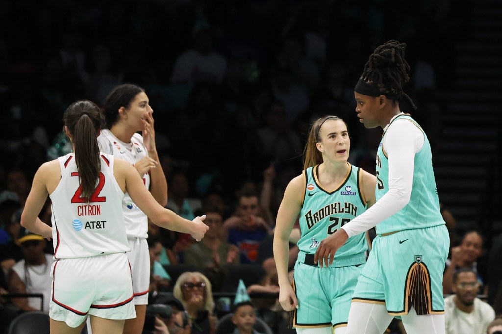 Sabrina Ionescu (20) celebrates with Jonquel Jones (35) during a WNBA basketball game.