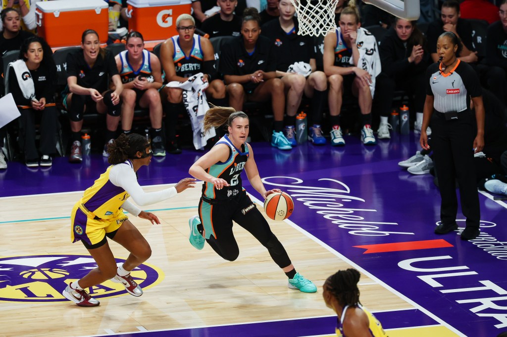 New York Liberty guard Sabrina Ionescu (20) dribbles the ball against a Los Angeles Sparks player.
