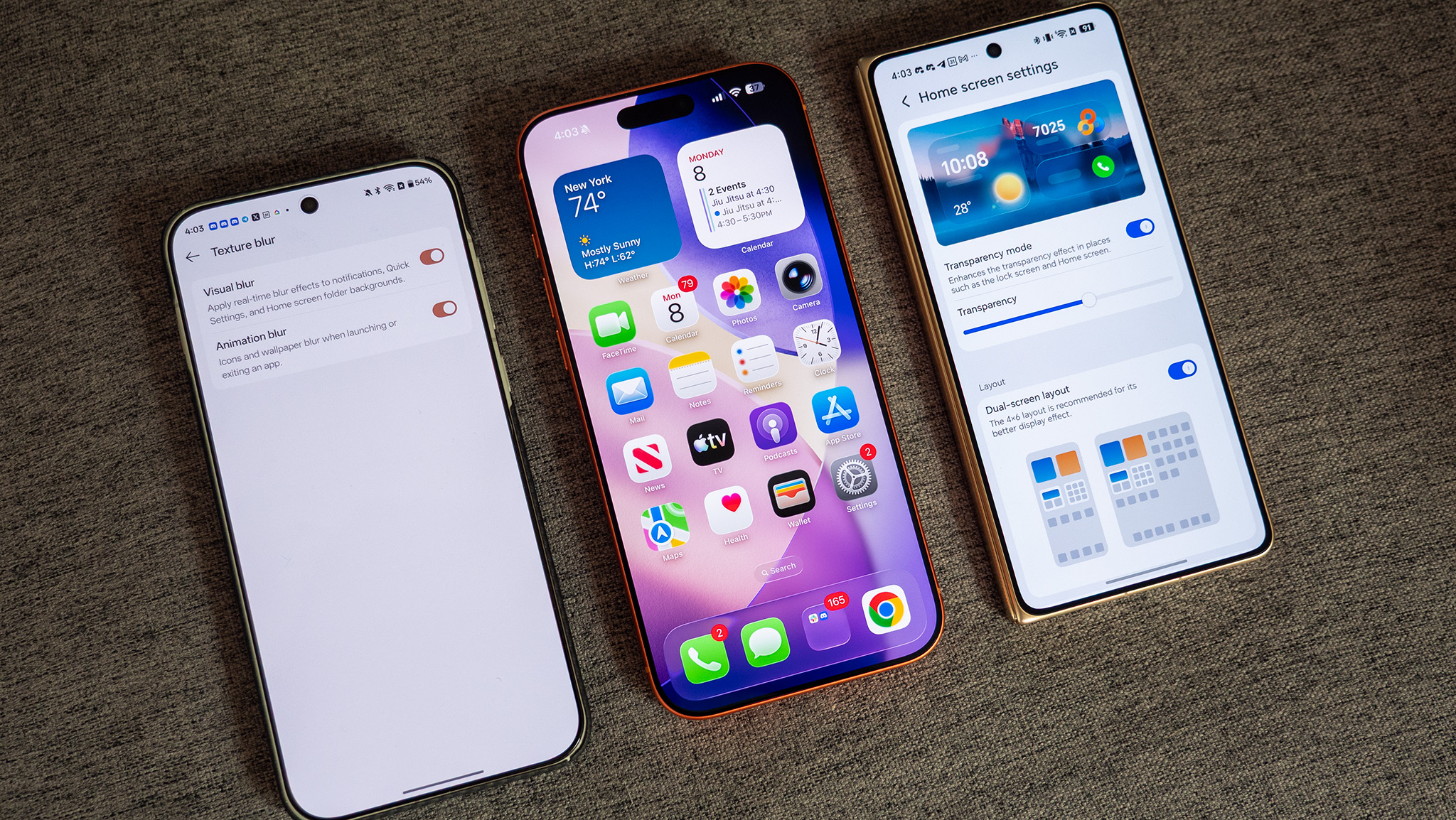 OS transparency options on a OnePlus 15 and Honor Magic V6 with an iPhone 17 Pro Max in between both phones