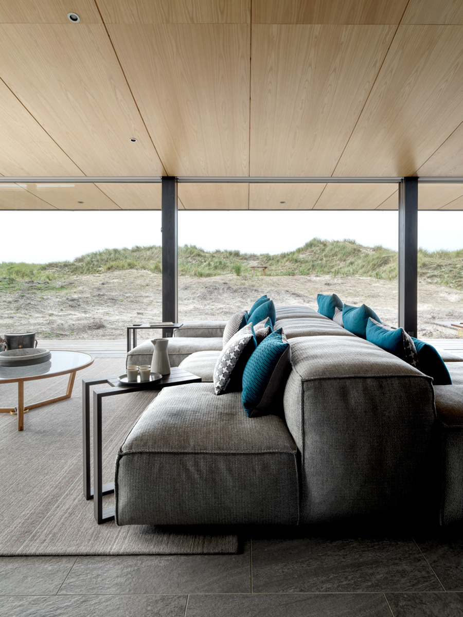 A contemporary living room with sofa in the middle of the space