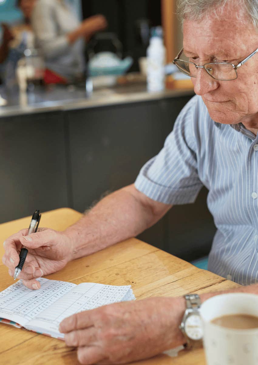 older man writing in small notebook retirement planning