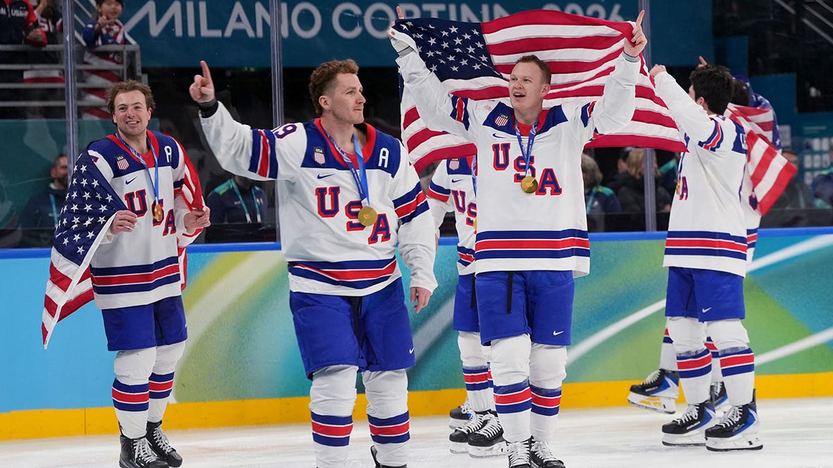 Brady Tkachuk and United States players celebrating on ice hockey rink.