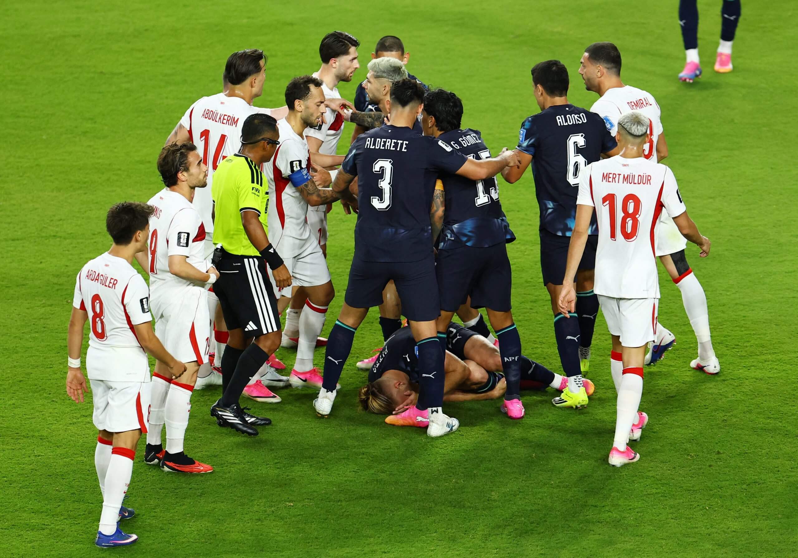 Players crowd the referee after Paraguay's Pitta (on the ground) had been fouled