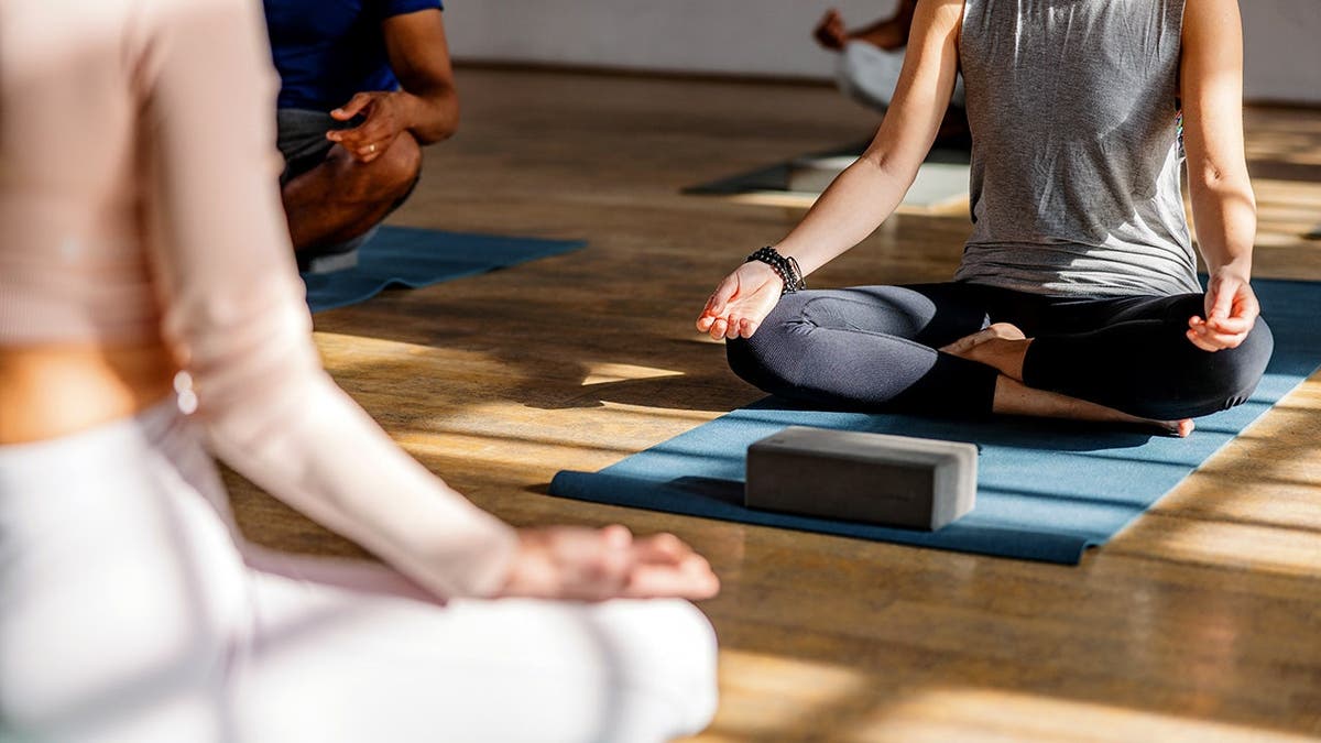 People sit on the floor and do yoga.