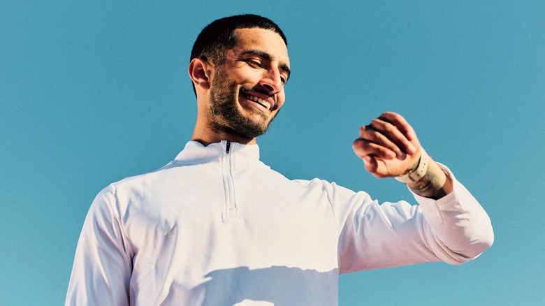 A smiling man checking his smartwatch