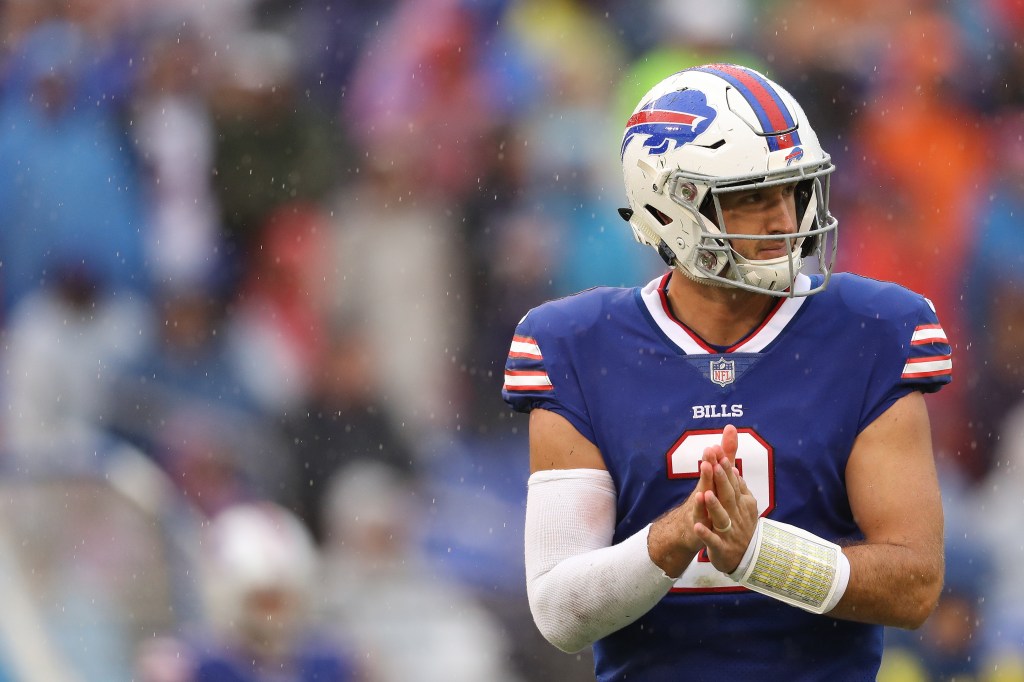 Nathan Peterman in a Buffalo Bills uniform with his hands together, looking on in the rain.