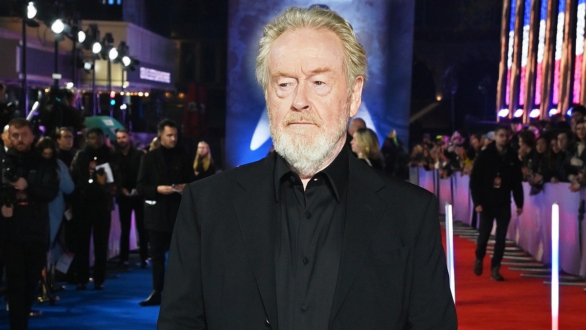 Sir Ridley Scott standing in a black suit at the UK premiere of Napoleon in London
