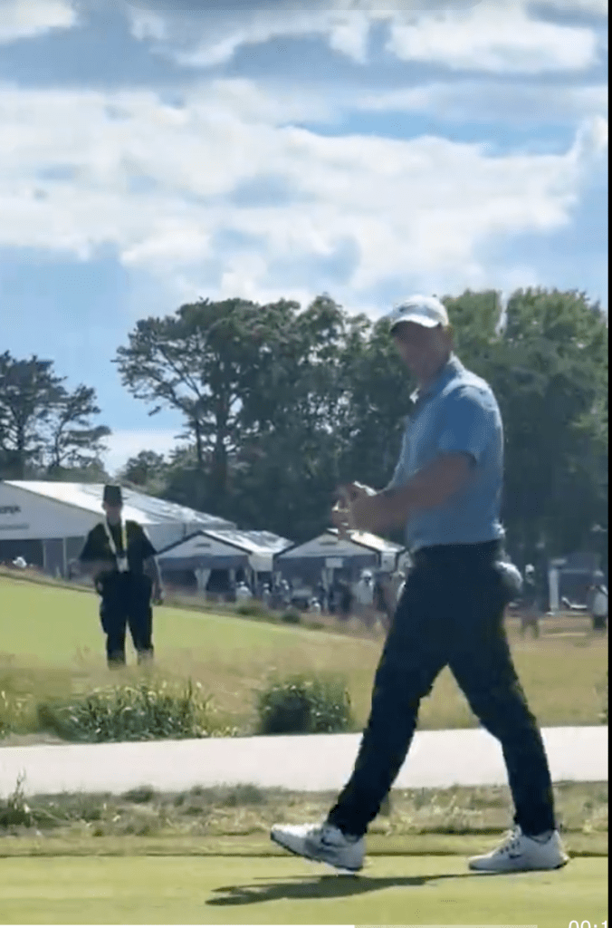 Rory McIlroy walking across the green.