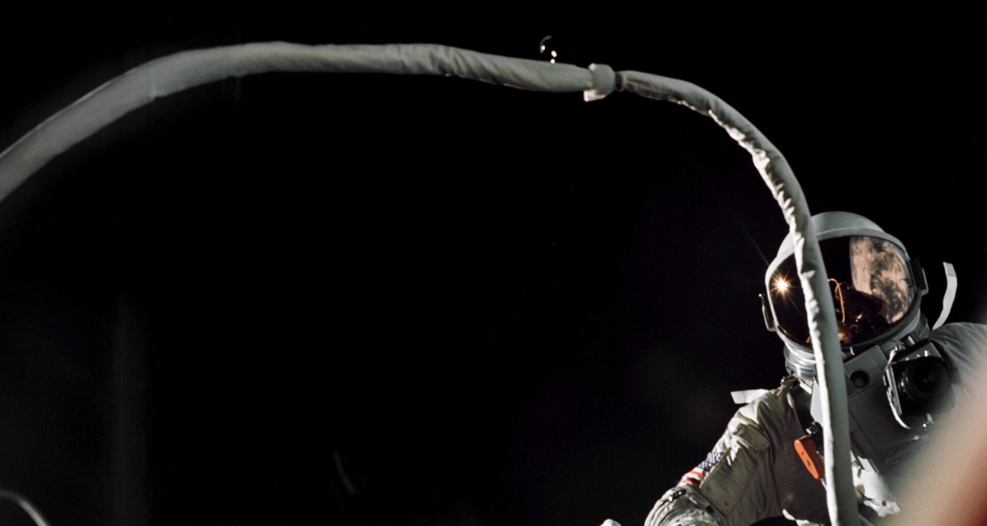 Gemini IX-A astronaut Gene Cernan is backdropped by the blackness of space during America’s second spacewalk on June 5, 1966. His umbilical drifts across the foreground, partially obscuring the view of the astronaut.