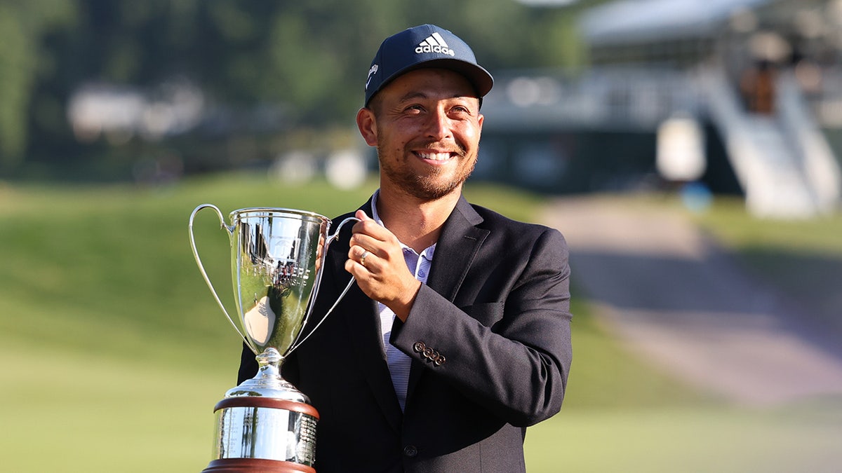 Xander Schauffele holding up the Travelers Championship Trophy after winning the golf tournament.