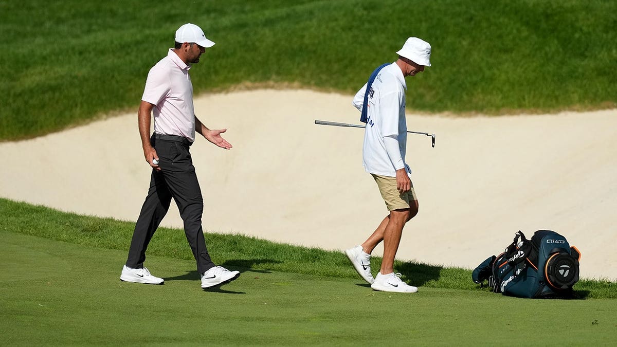 Scottie Scheffler talking with caddie Ted Scott while walking off the 16th green at Muirfield Village Golf Club